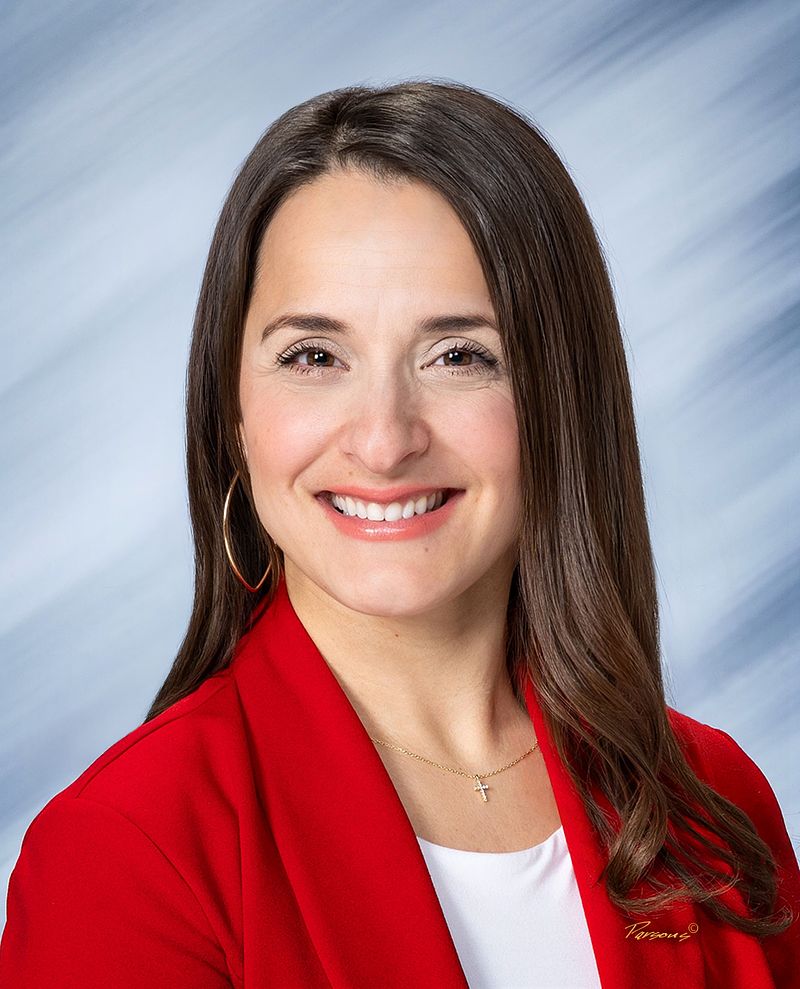 Business headshot of a woman in a red blazer