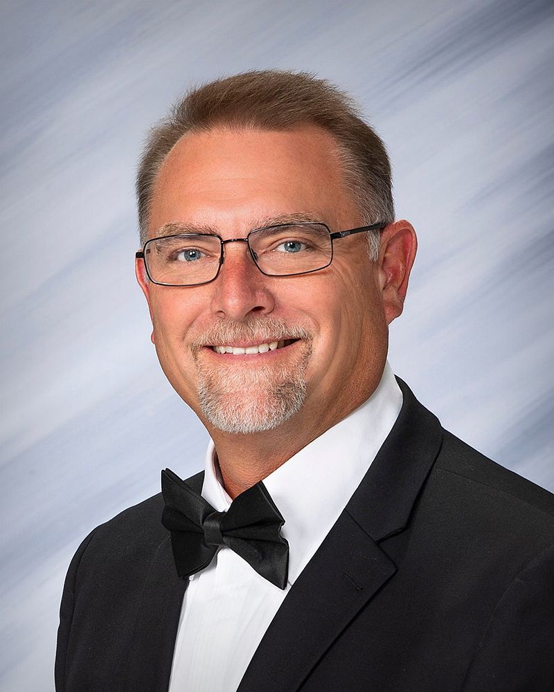 Business headshot of a man in a tuxedo and bow tie