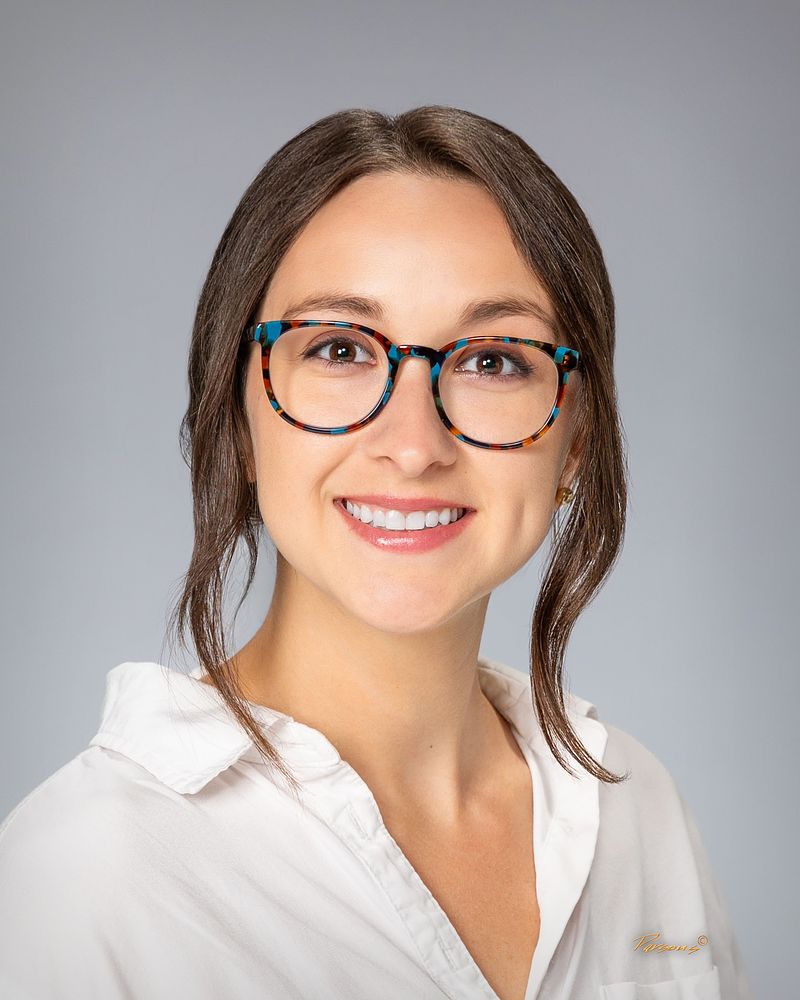 Business headshot of a woman in glasses and a white shirt
