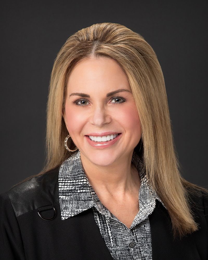 Business headshot of a woman on a dark backdrop