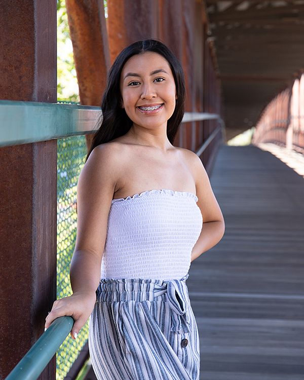 Senior leaning on the railing of a footbridge