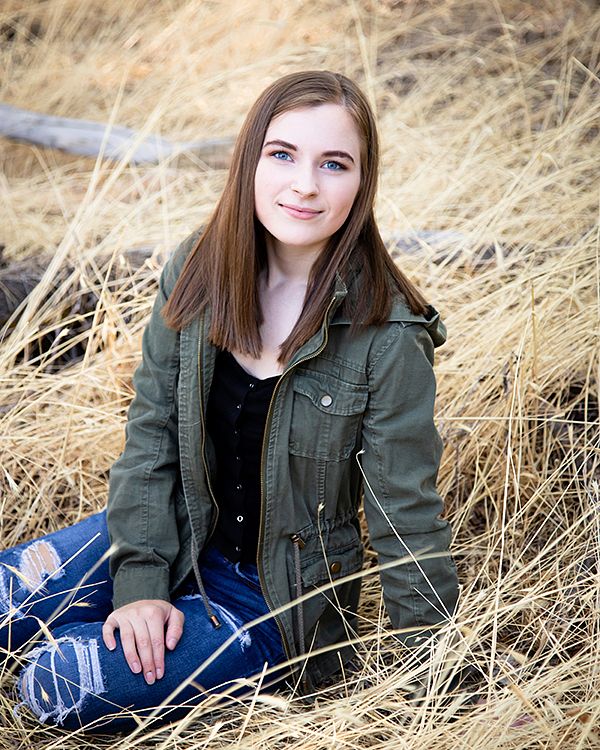 Senior sitting in tall dry grass