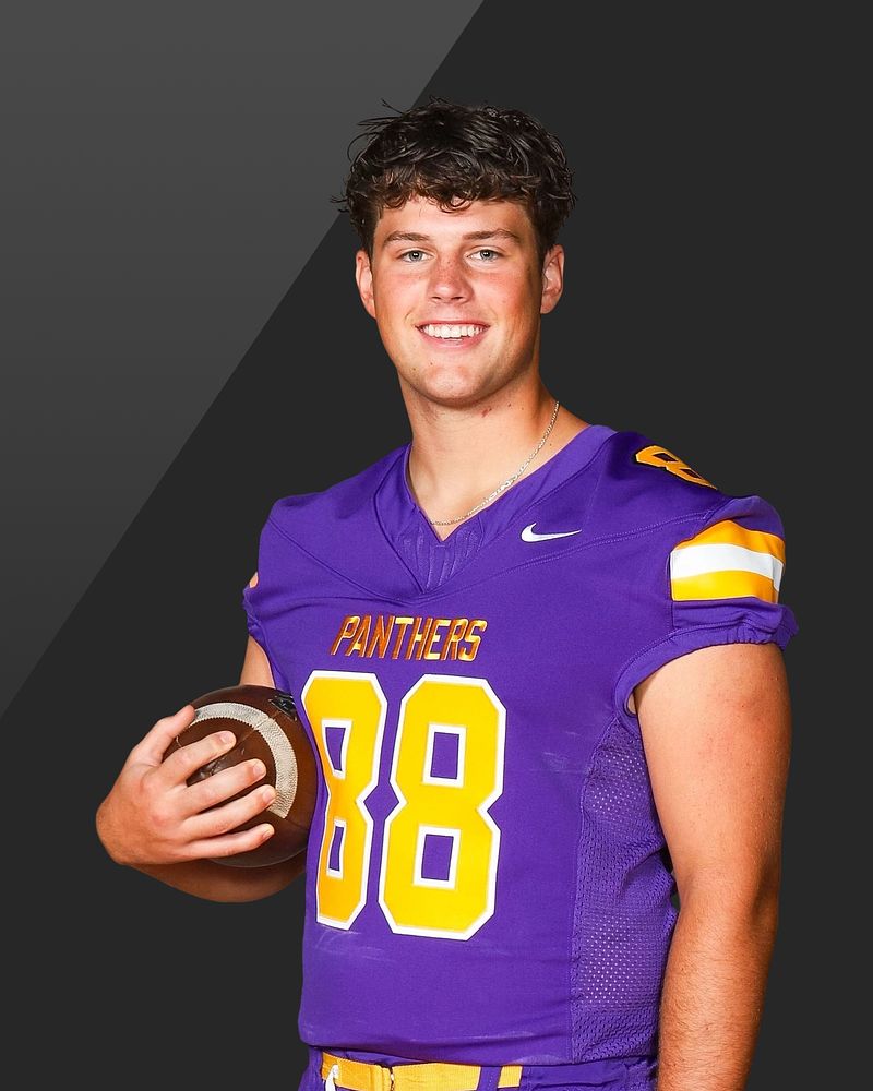 Football player holding a ball against a dark studio background