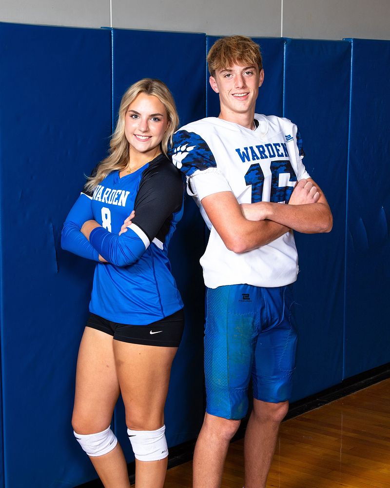 Volleyball player and football player posed back to back in the gym